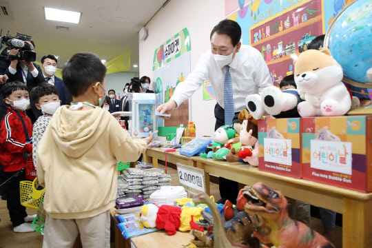 윤석열 대통령이 27일 세종시 아이누리 어린이집을 방문해 아나바다 시장놀이를 참관하고 있다.<연합뉴스>